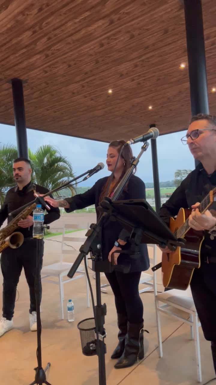 Bruna Pires com violão e sax em apresentação ao vivo